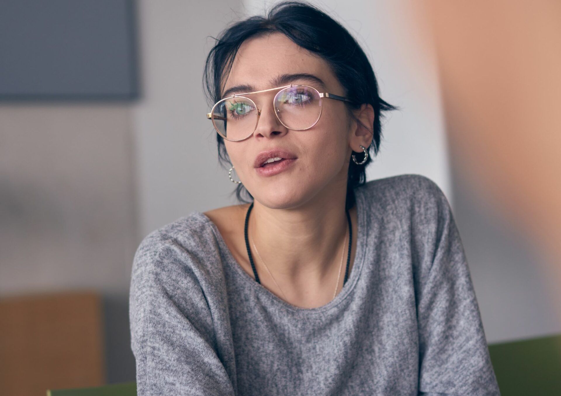 En mörkhårig kvinna med glasögon pratar med någon vi inte kan se i bild.