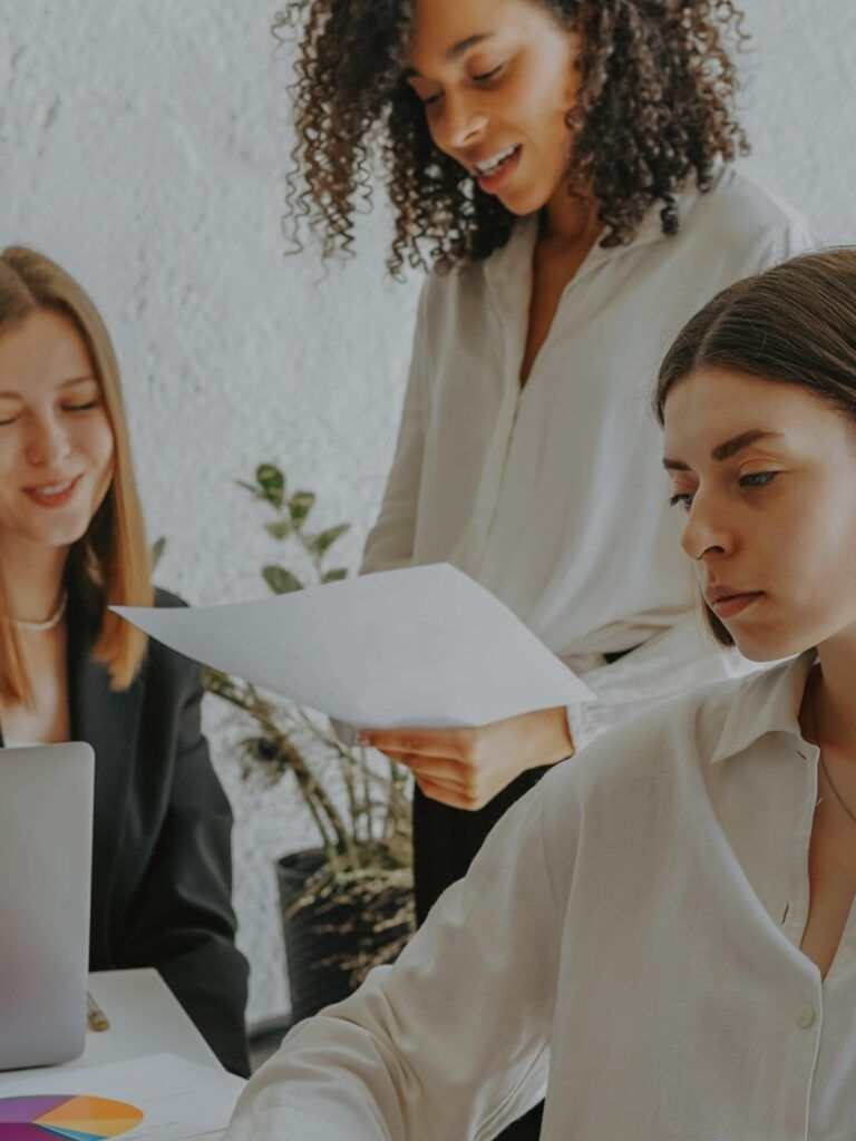 Tre kvinnor jobbar tillsammans i kontorsmiljö
