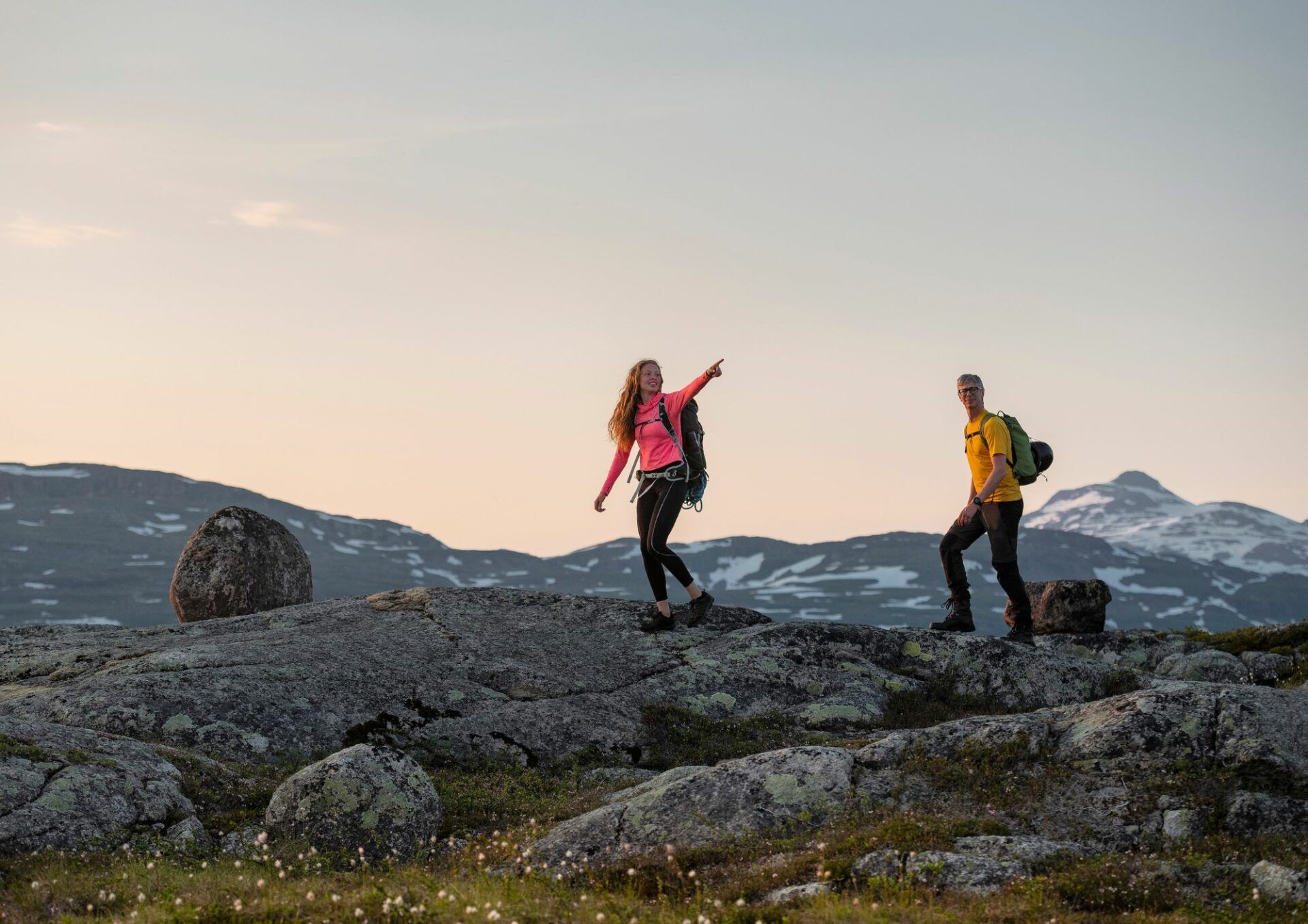 Två perspner vandrar i fjällmiljö. Den ena personen pekar mot något i fjärran.