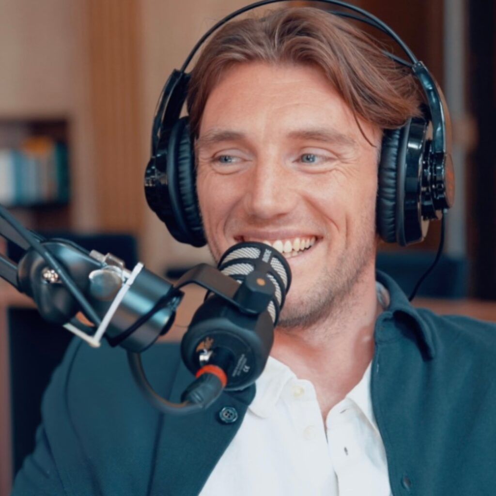 Foto på Peter Kurzwelly framför en mikrofon i en poddstudio