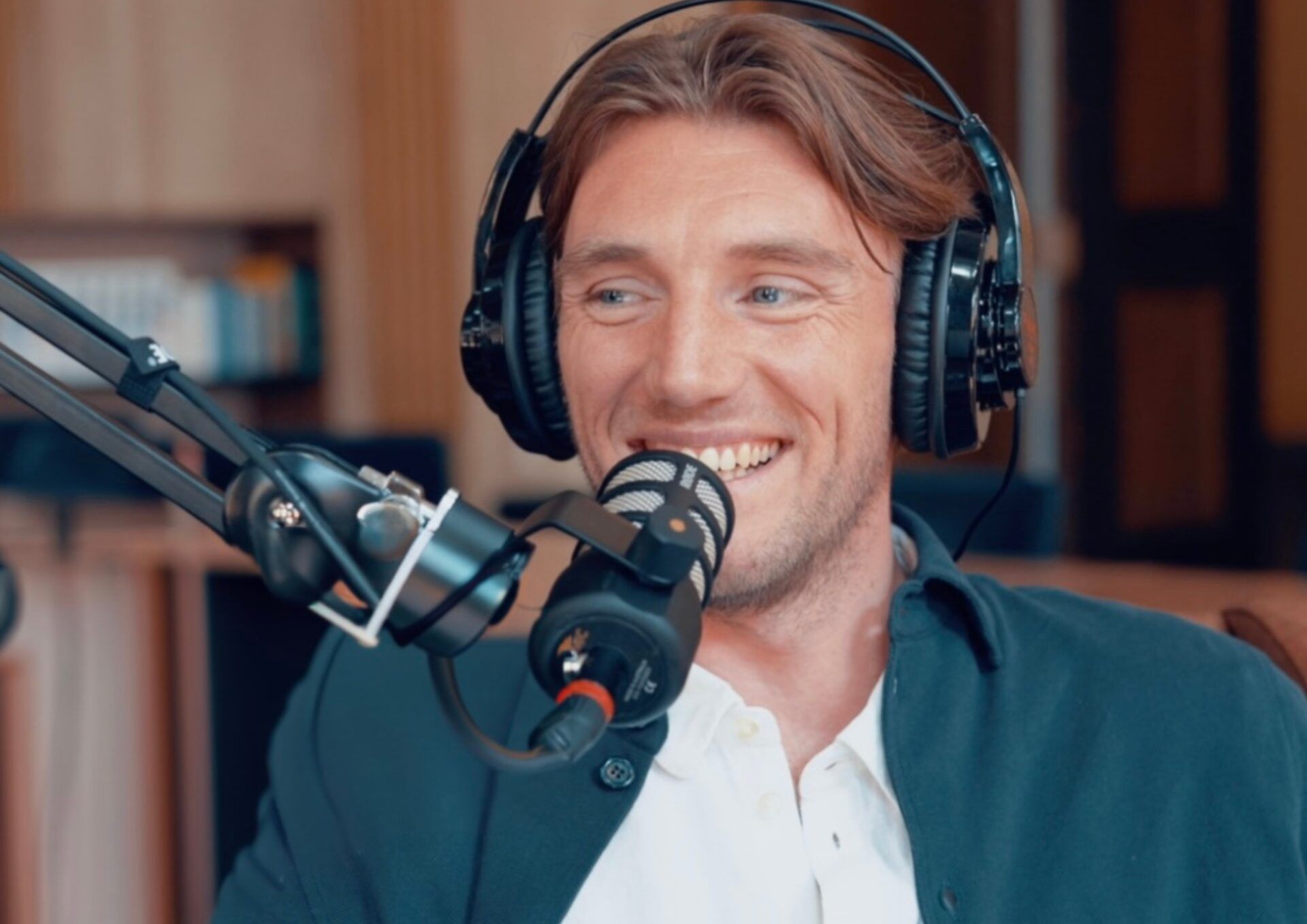 Foto på Peter Kurzwelly framför en mikrofon i en poddstudio