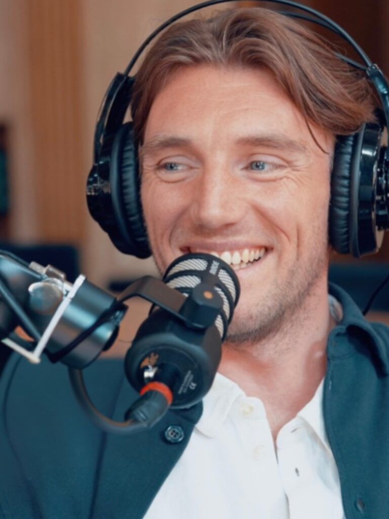 Foto på Peter Kurzwelly framför en mikrofon i en poddstudio