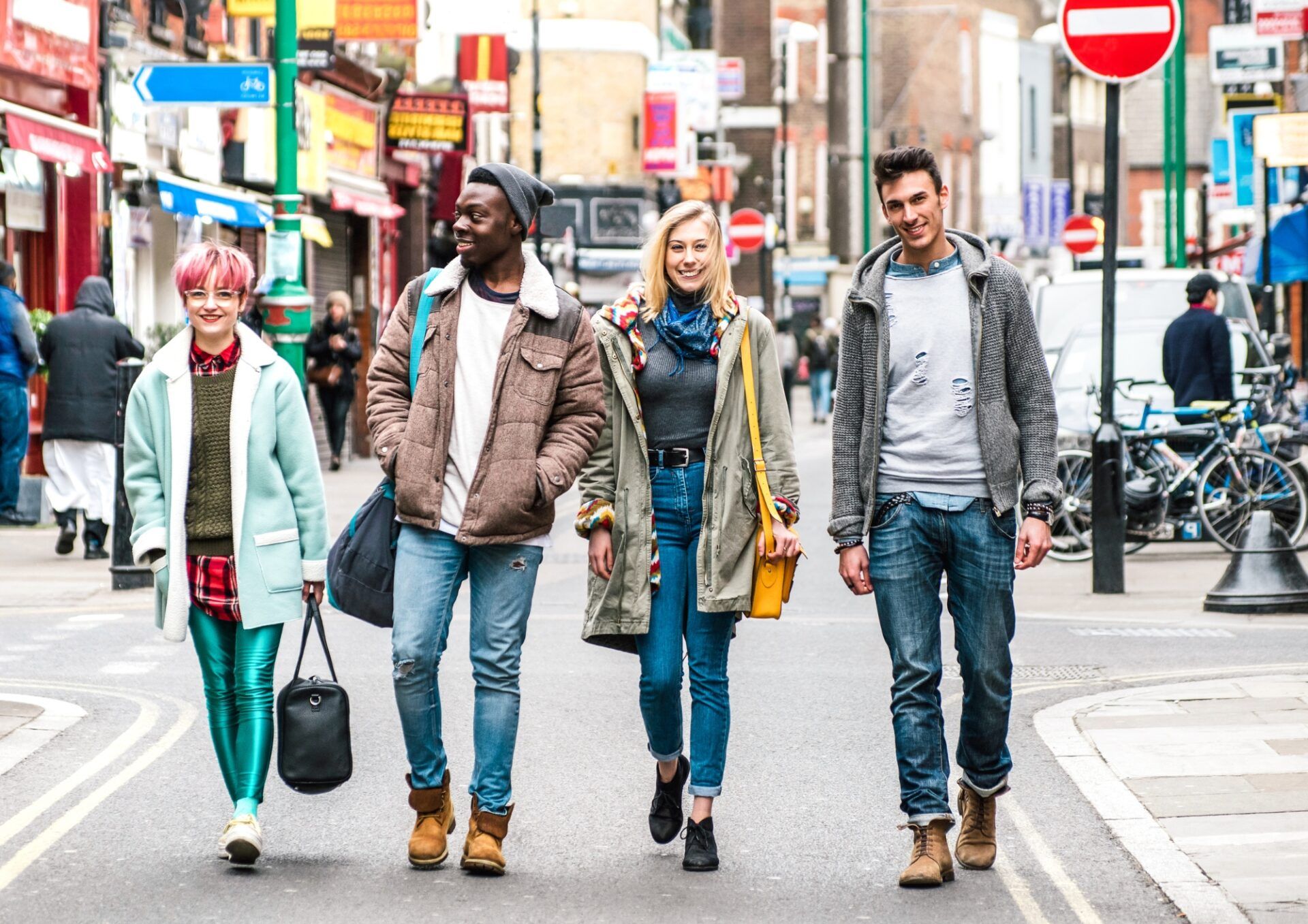 Fyra glada personer sitter ner bredvid varandra vid ett bord och tittar in i en datorskärm.