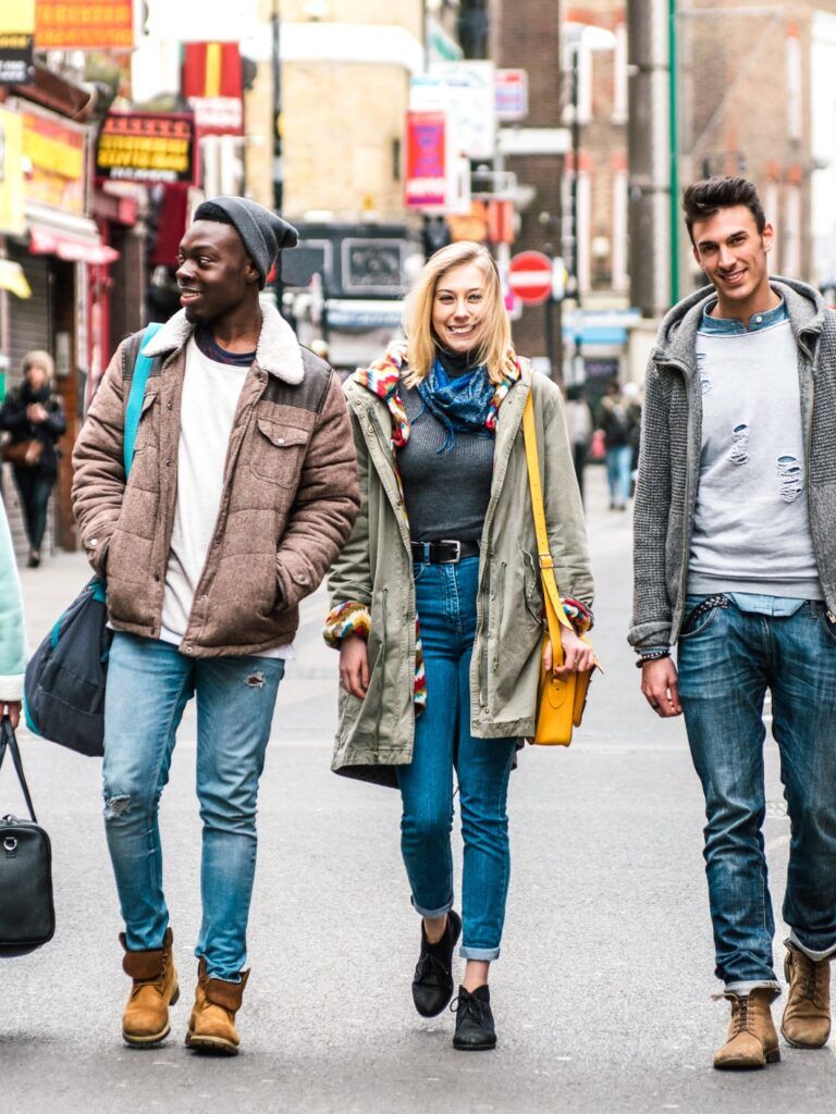 Fyra glada personer sitter ner bredvid varandra vid ett bord och tittar in i en datorskärm.