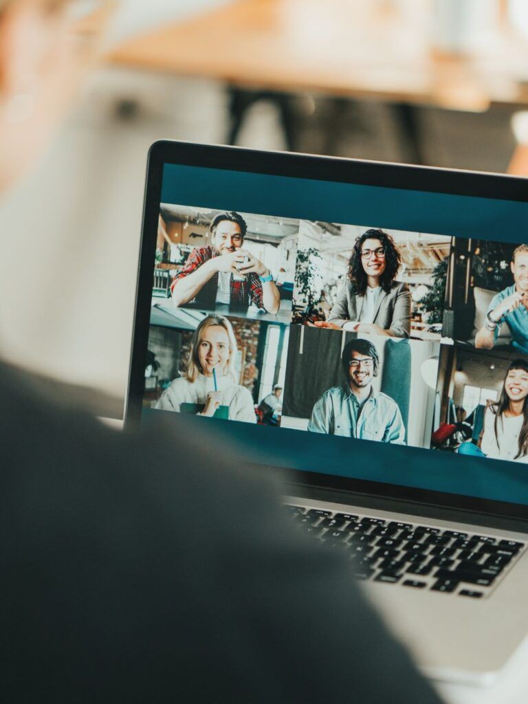 Ett digitalt möte med glada medarbetare på skärmen.