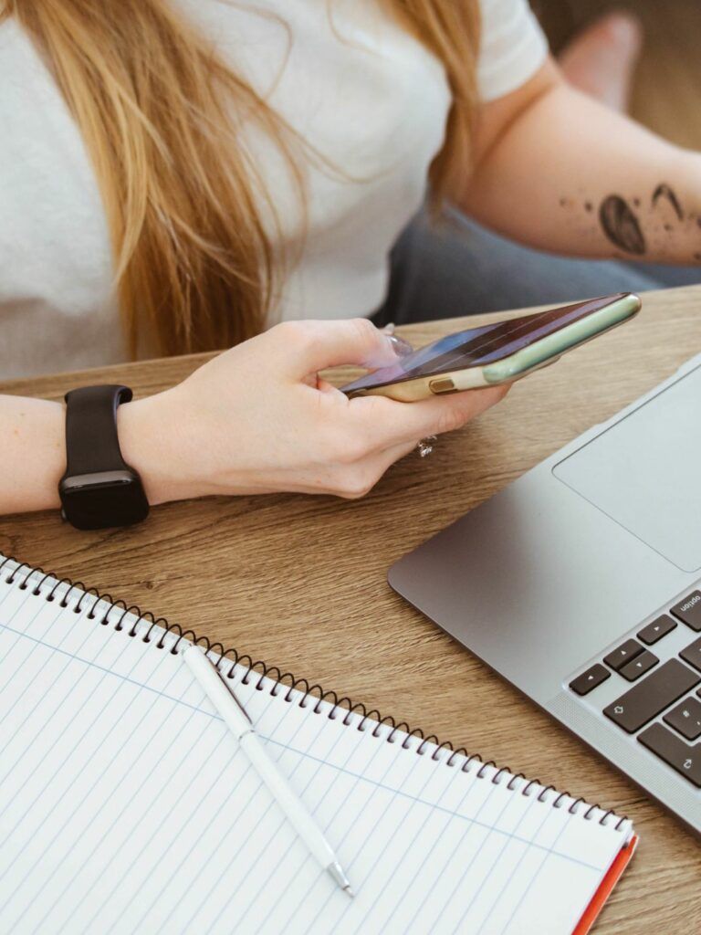 En kvinna arbetar med sin dator och laptop