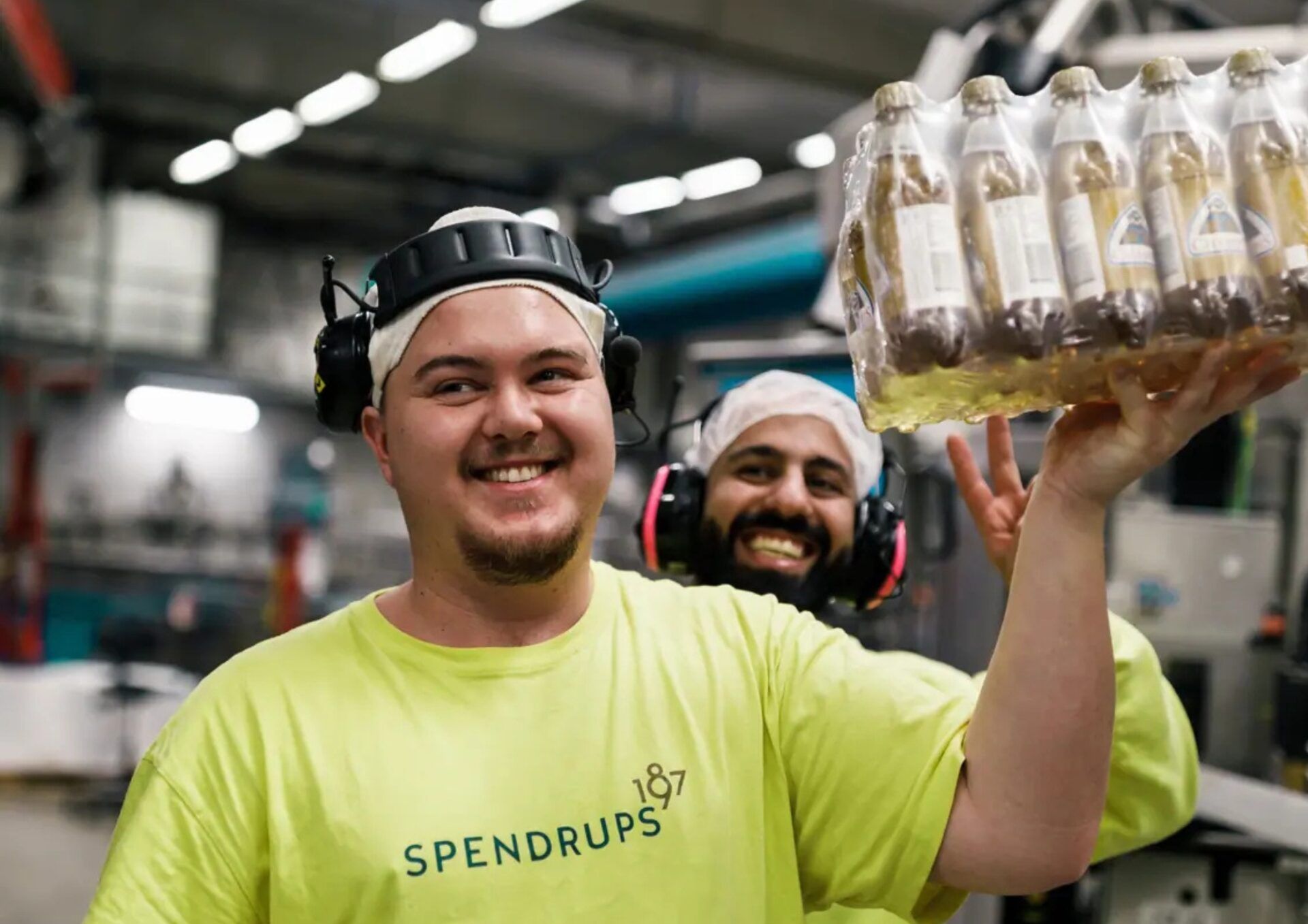 Leende person med hörselskydd som håller upp ett nät med trocadero