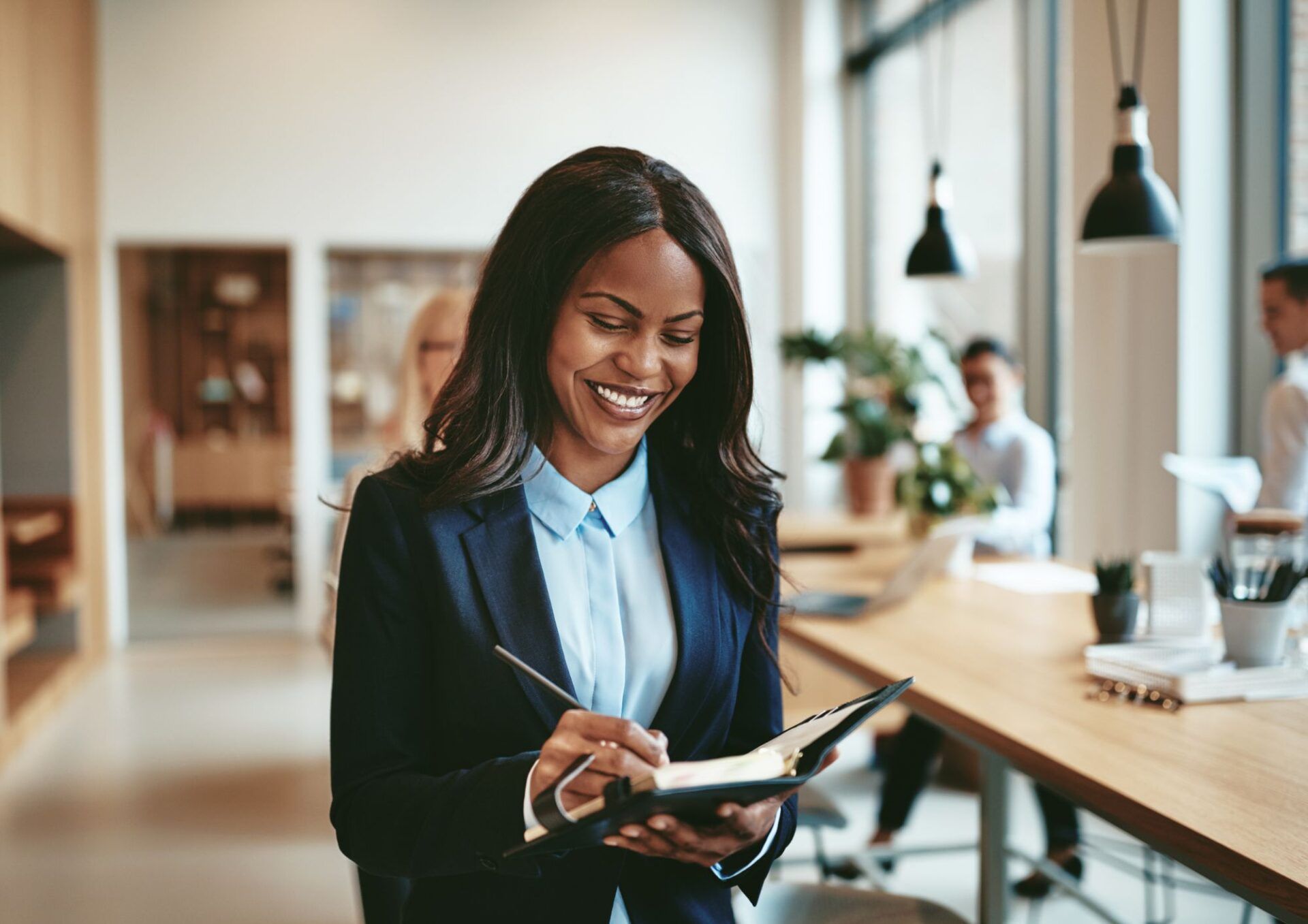 Kvinna ler och skriver i en bok