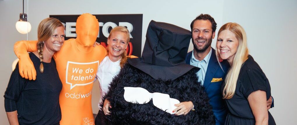 Gruppbild på medarbetare på Sector Alarm samt på Oddworksmannen i orange dräkt. En person är utklädd till Morran i Mumin.